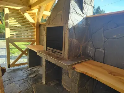 a porch with a tv on a stone wall at Dzika Dziura z jacuzzi in Zawoja