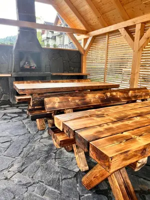 a row of wooden benches in front of a fireplace at Dzika Dziura z jacuzzi in Zawoja