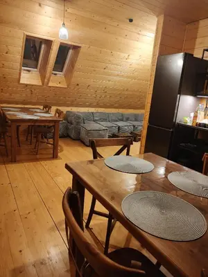 a living room with wooden walls and tables and a couch at Dzika Dziura z jacuzzi in Zawoja