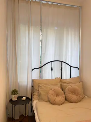 a bed with two pillows on it in front of a window at Cozy Rooms Old Town in Kraków