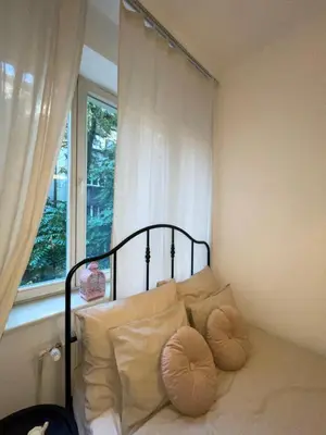 a bed with pillows in a room with a window at Cozy Rooms Old Town in Kraków