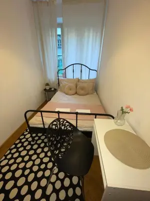 a small bedroom with a bed and a chair at Cozy Rooms Old Town in Kraków
