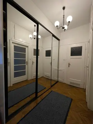 a mirror in a room with white doors and a rug at Cozy Rooms Old Town in Kraków
