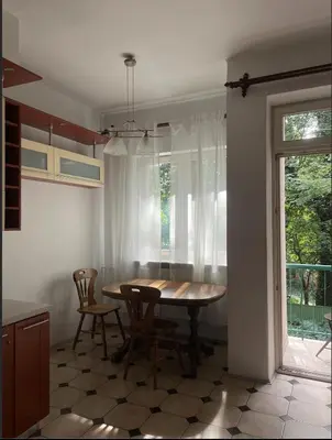 a kitchen with a table and chairs and a window at Cozy Rooms Old Town in Kraków