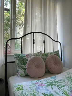a bed with two pillows on it with a window at Cozy Rooms Old Town in Kraków