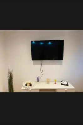 a white table with a television on a wall at Beer Street Apartment in Kraków
