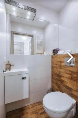 a bathroom with a toilet and a sink and a mirror at Beer Street Apartment in Kraków