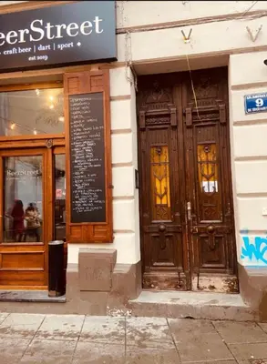 a store front with wooden doors on a building at Beer Street Apartment in Kraków