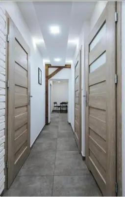 a hallway with wooden doors and a table at Beer Street Apartment in Kraków