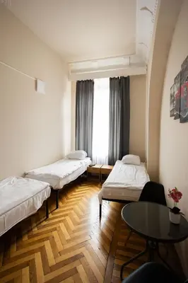 a room with three bunk beds and a table at FiveHostel in Kraków