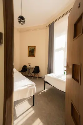 a room with three beds in a room at FiveHostel in Kraków