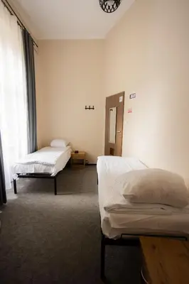 a living room with two beds and a table at FiveHostel in Kraków