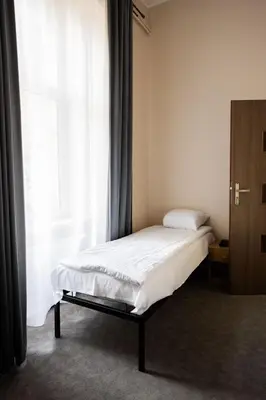 a room with two beds and a table in it at FiveHostel in Kraków