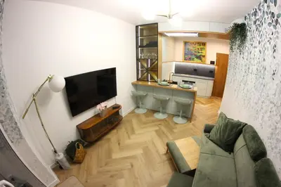 a living room with a large television and a couch at Nenufar Cracow Garden Kraków Parter Free Darmowy Parking Ogród Netflix Klimatyzacja in Kraków