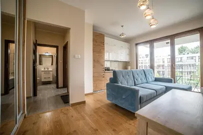 a living room with a blue couch and a kitchen at Jop in Kraków