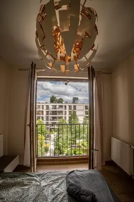 a bedroom with a large window with a large chandelier at Jop in Kraków