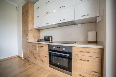 a kitchen with wooden cabinets and a stove top oven at Jop in Kraków