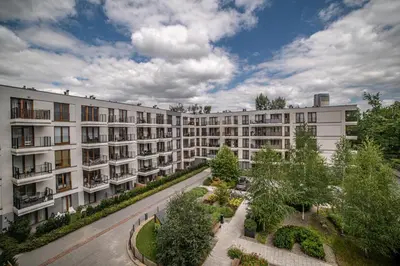 an apartment building with a courtyard with trees and bushes at Jop in Kraków