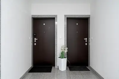 a kitchen with white cabinets and a table at Skowronia Modern Apartment by BookingHost in Kraków