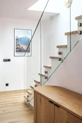 a staircase in a white room with a picture on the wall at Gontowe Zacisze in Zawoja