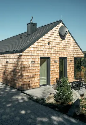 a brick building with a patio and a table at Gontowe Zacisze in Zawoja
