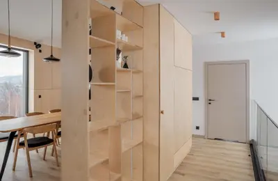 a dining room with a wall of shelves at Gontowe Zacisze in Zawoja