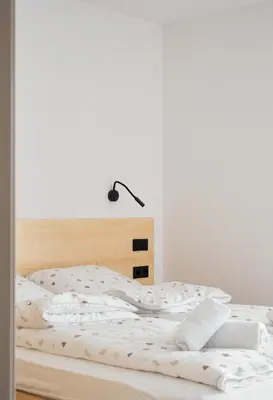 an unmade bed with a lamp on top of it at Gontowe Zacisze in Zawoja
