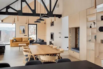 a dining room and living room with a table and chairs at Gontowe Zacisze in Zawoja