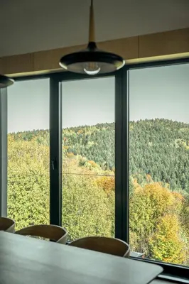 a room with a table and chairs looking out a window at Gontowe Zacisze in Zawoja