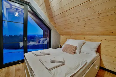 a bedroom with a white bed with towels on it at Wzgórza Jordanowskie in Jordanów