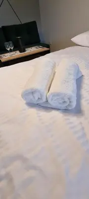 a white bed with two towels on it at Apartament Miód Malina in Olszówka