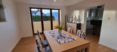 a dining room table with a vase of flowers on it at Apartament Miód Malina in Olszówka