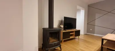 a living room with a black stove and a tv at Apartament Miód Malina in Olszówka