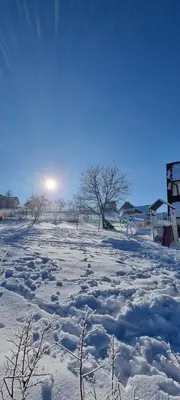 a field covered in snow with the sun in the background at Apartament Miód Malina in Olszówka