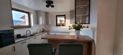 a kitchen with a table with a vase of flowers on it at Apartament Miód Malina in Olszówka