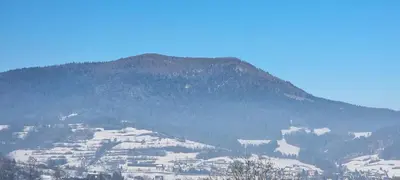 a snow covered mountain with a town on it at Apartament Miód Malina in Olszówka