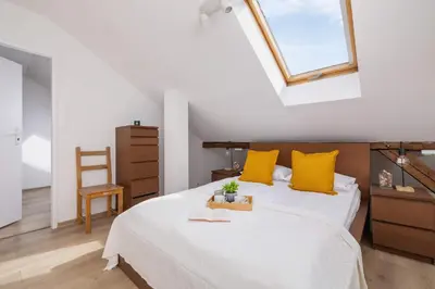 a bedroom with a bed with yellow pillows and a window at Klimatyzowany Apartament z Dwiema Sypialniami w Centrum Krakowa Blisko Rynku i Parku by Noclegi Renters in Kraków