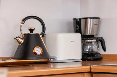 a black tea kettle on a counter next to a blender at Klimatyzowany Apartament z Dwiema Sypialniami w Centrum Krakowa Blisko Rynku i Parku by Noclegi Renters in Kraków