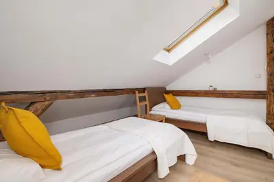 two beds in a room with white and yellow pillows at Klimatyzowany Apartament z Dwiema Sypialniami w Centrum Krakowa Blisko Rynku i Parku by Noclegi Renters in Kraków