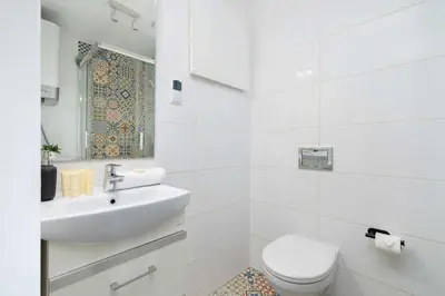a white bathroom with a toilet and a sink at Klimatyzowany Apartament z Dwiema Sypialniami w Centrum Krakowa Blisko Rynku i Parku by Noclegi Renters in Kraków