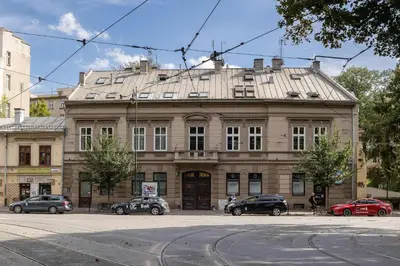 a large building with cars parked in front of it at Klimatyzowany Apartament z Dwiema Sypialniami w Centrum Krakowa Blisko Rynku i Parku by Noclegi Renters in Kraków