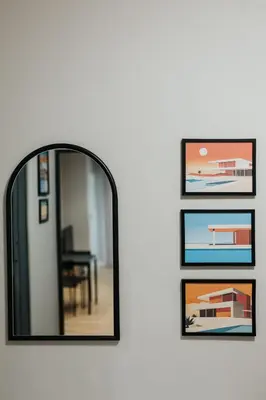 a mirror hanging on a wall with pictures at Domus Aurea Free Parking Garden Balcony in Kraków
