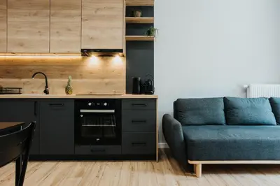 a kitchen with a blue couch next to a counter at Domus Aurea Free Parking Garden Balcony in Kraków
