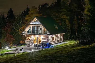 a small log cabin with a green roof at Zielone Wzgórze in Sidzina