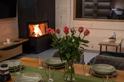 a table with a vase of flowers on a table with a fireplace at Zielone Wzgórze in Sidzina