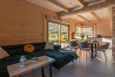 a living room with a green couch and a table at Zielone Wzgórze in Sidzina