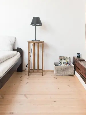 a room with a bed and a lamp on a wooden floor at Charming Rustic Old Town Apartment in Kraków