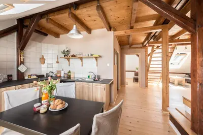 a kitchen and dining room with a black table and chairs at Charming Rustic Old Town Apartment in Kraków