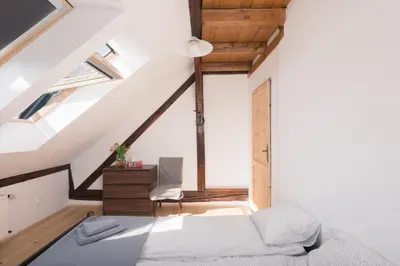 an attic bedroom with a bed and a desk at Charming Rustic Old Town Apartment in Kraków
