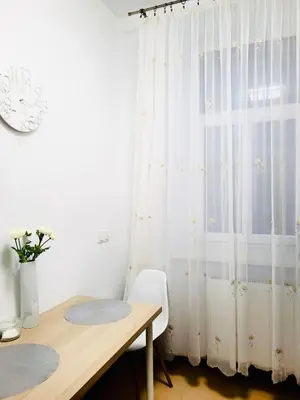 a desk and a window with a white curtain at Castle Street in Kraków